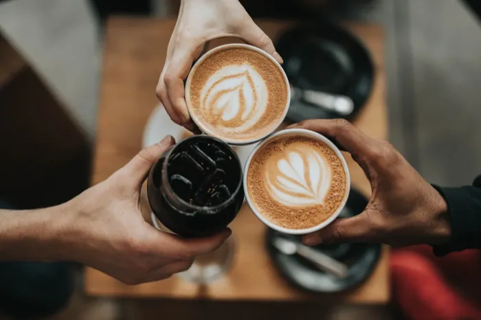 Coffee cups being raised in a toast